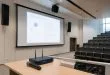 guide pratique pour associer un micro et des enceintes à un écran de projection dans un amphithéâtre afin d'optimiser la qualité sonore et l'expérience audiovisuelle.