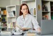 Redhead tutor engaging online learning in library