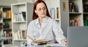 Redhead tutor engaging online learning in library