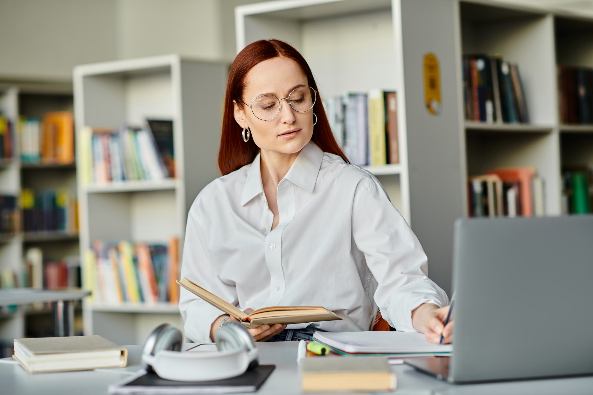 Redhead tutor engaging online learning in library